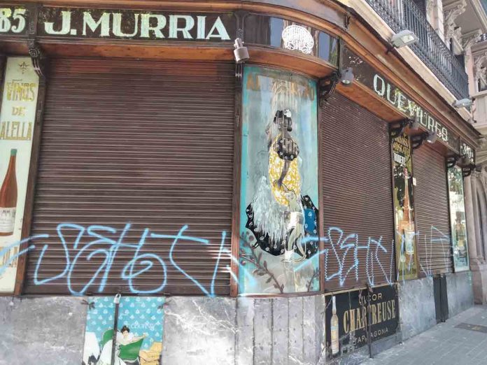 La fachada centenaria de Queviures Múrria, vandalizada con grafitis